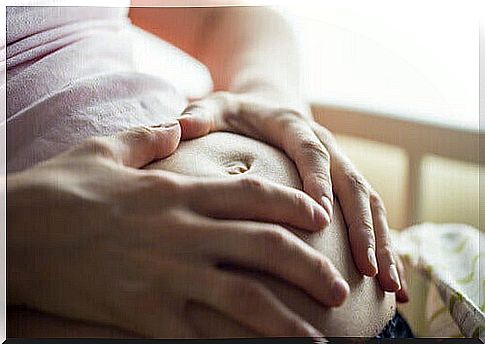 pregnant woman putting her hands on her belly