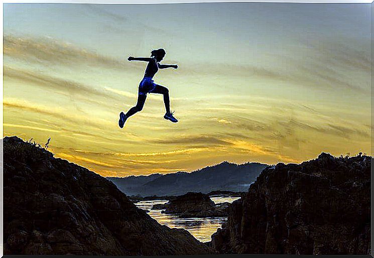 woman jumping from hill to hill