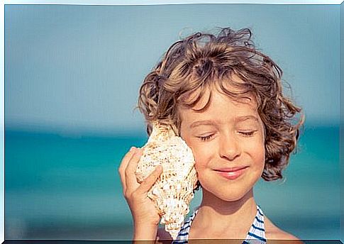 child listening in a seashell